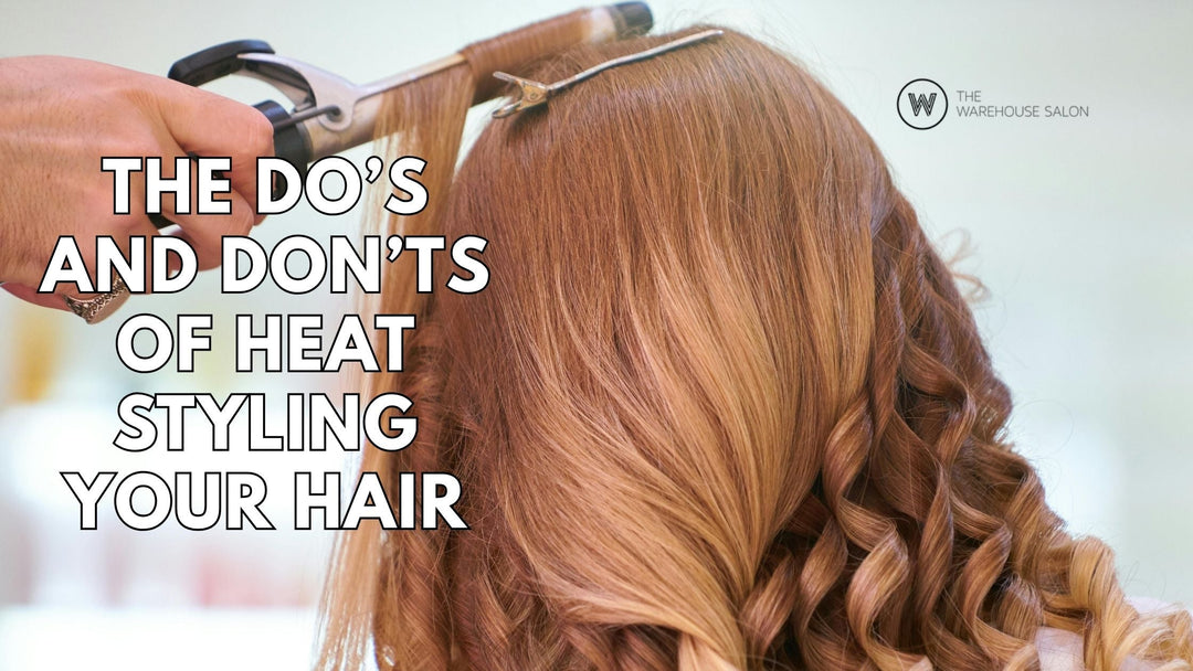 Stylist applying heat protectant spray before flat ironing hair in salon.